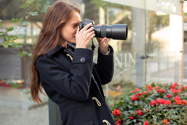 Mulher feliz de férias fotografando com câmera na rua da cidade. Se divertindo na cidade com câmera, foto de viagem do fotógrafo.