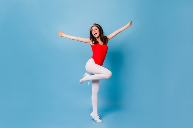 Foto grátis mulher feliz dos anos 80 se divertindo na parede azul