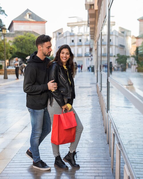 Mulher feliz e jovem na rua perto de vitrine