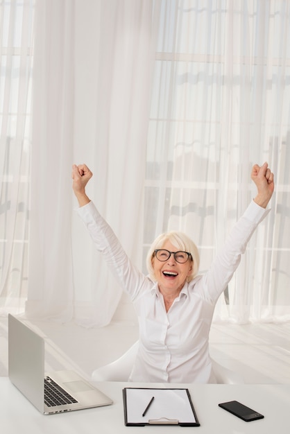 Foto grátis mulher feliz e sua mesa de trabalho