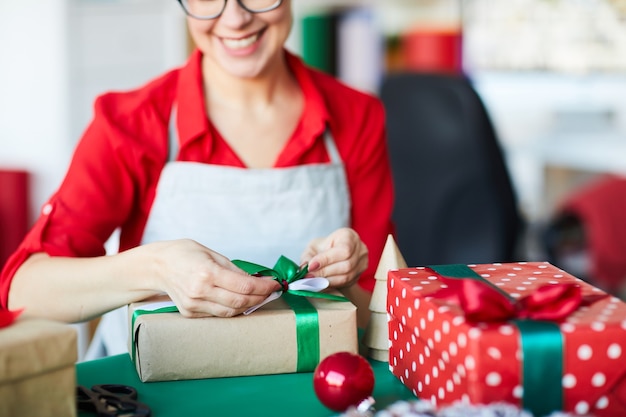 Mulher feliz embrulhando presentes ou presentes de natal