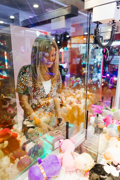 Mulher feliz jogando máquina de arcade