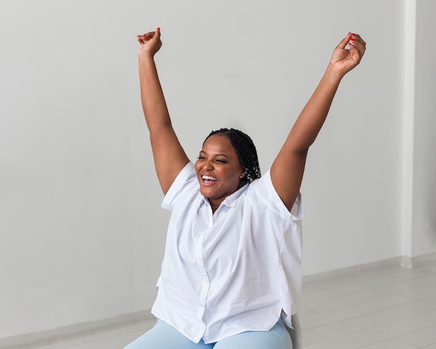 Mulher feliz na cadeira com tiro médio