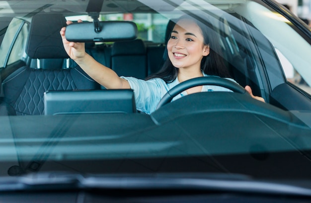 Mulher feliz na concessionária de carros