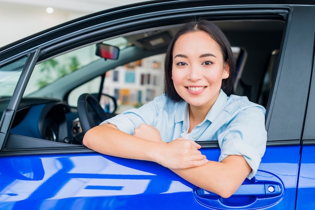 Foto grátis mulher feliz na concessionária de carros