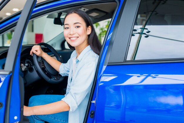 Mulher feliz na concessionária de carros