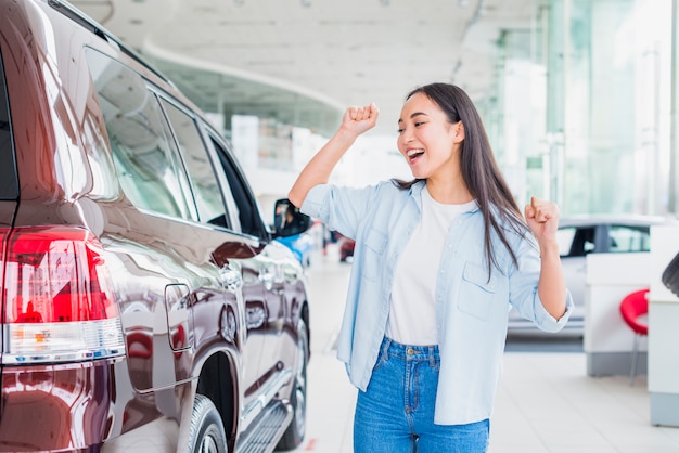 Mulher feliz na concessionária de carros