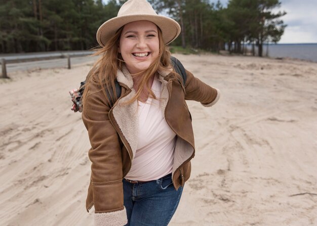 Mulher feliz na praia com tiro médio