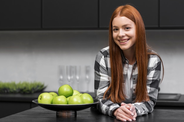 Mulher feliz posando na cozinha