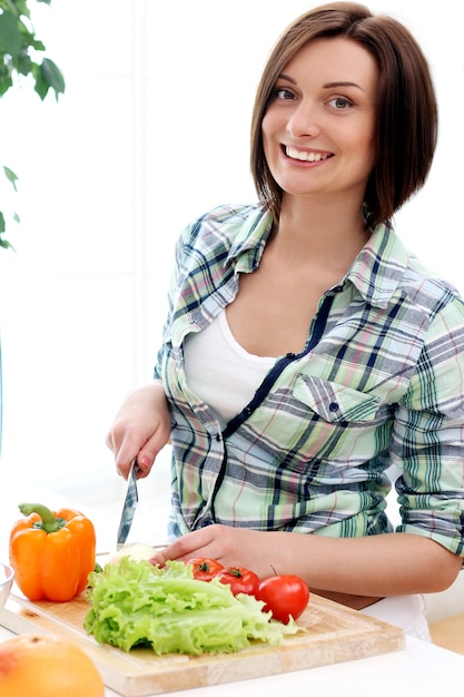 Mulher feliz, preparando uma salada saudável