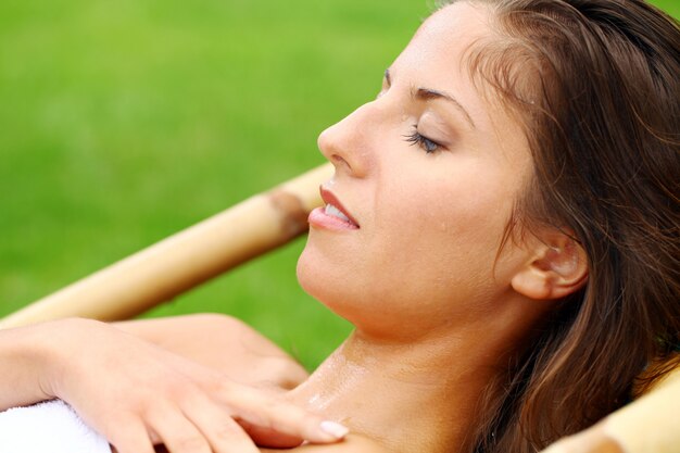 Mulher feliz relaxante na espreguiçadeira