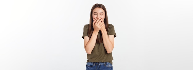 Mulher feliz rindo cobrindo a boca com as mãos isoladas sobre fundo cinza