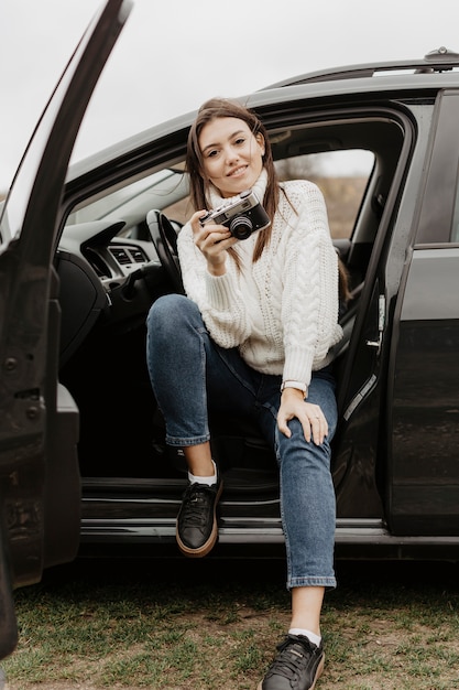 Foto grátis mulher feliz, segurando a câmera tiro completo