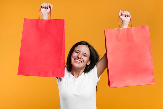 Mulher feliz segurando sacolas de compras à venda