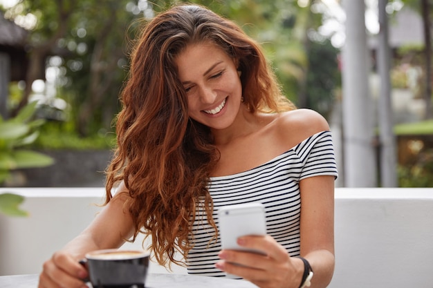 Foto grátis mulher feliz sentada em uma cafeteria