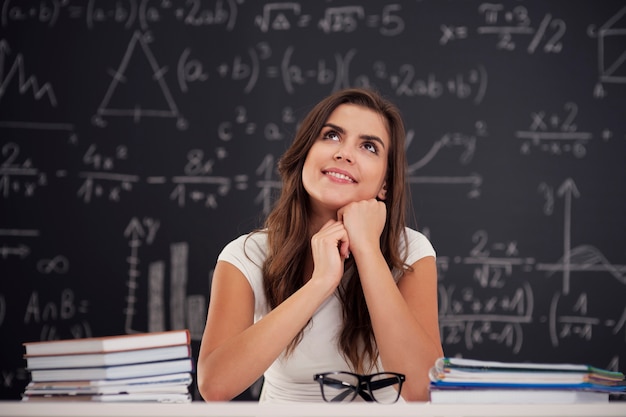 Mulher feliz sentada na sala de aula olhando para cima