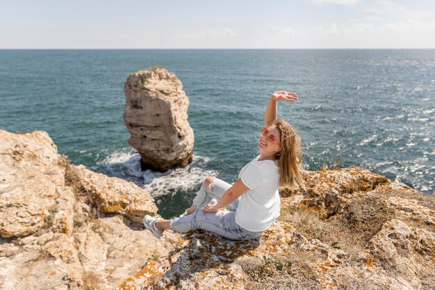 Mulher feliz sentada nas pedras