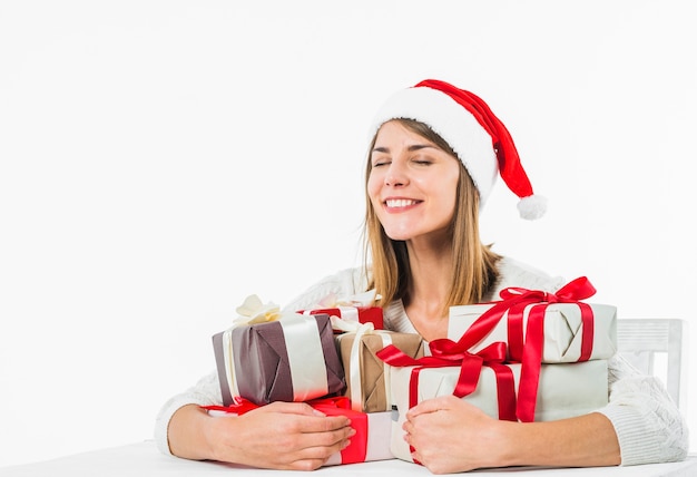 Mulher feliz sentado à mesa com caixas de presente