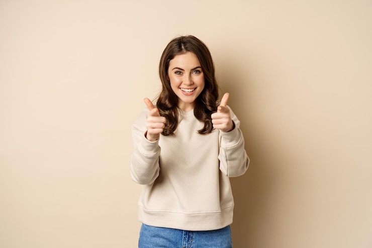 Foto grátis mulher feliz sorridente escolhendo você apontando os dedos para a câmera e rindo convidando as pessoas em pé...