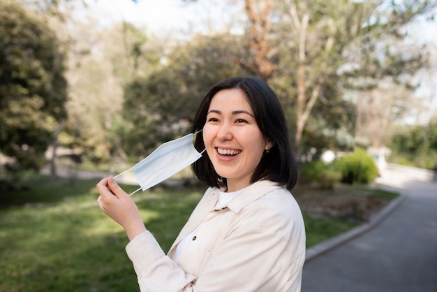 Foto grátis mulher feliz tirando a máscara de tiro médio