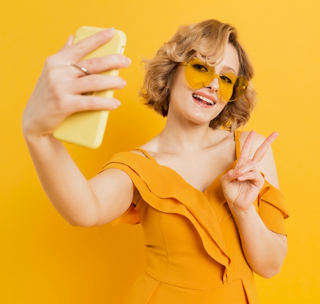 Mulher feliz tomando uma selfie enquanto usava óculos de sol