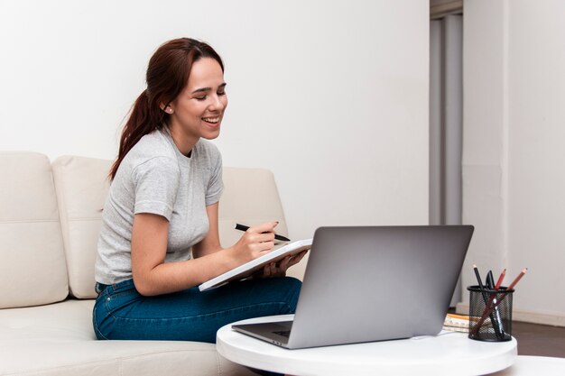 Mulher feliz trabalhando enquanto olha para o laptop