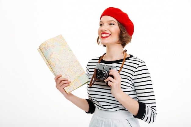 Mulher feliz turista com câmera segurando o mapa.