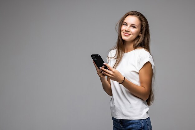 Mulher feliz usando smartphone cinza