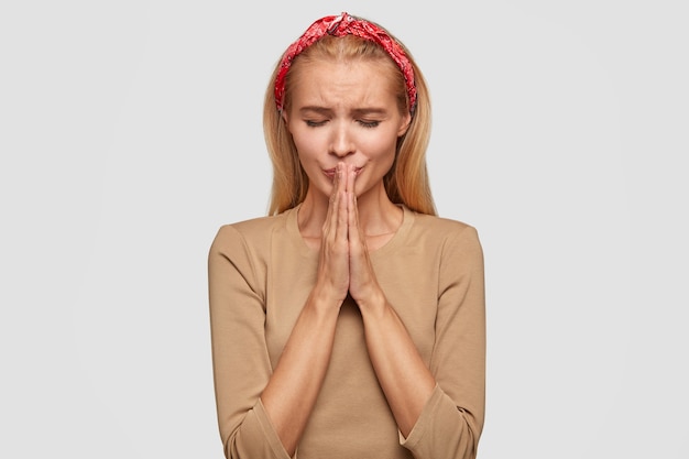 Foto grátis mulher fiel deprimida estando em pânico, em situação estressante, orando