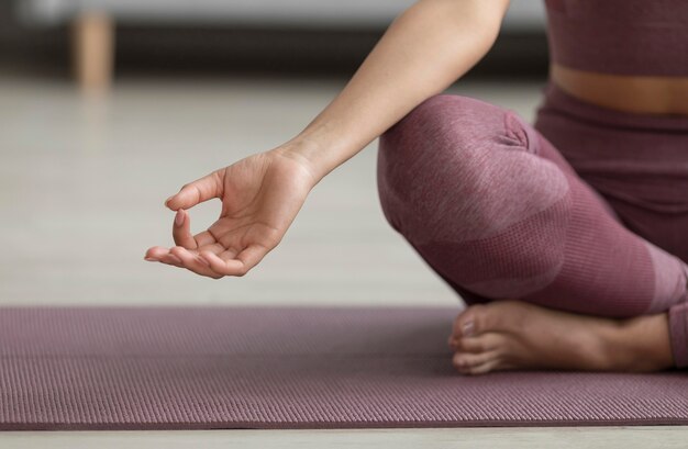 Mulher fitness fazendo ioga em uma esteira de ioga em casa