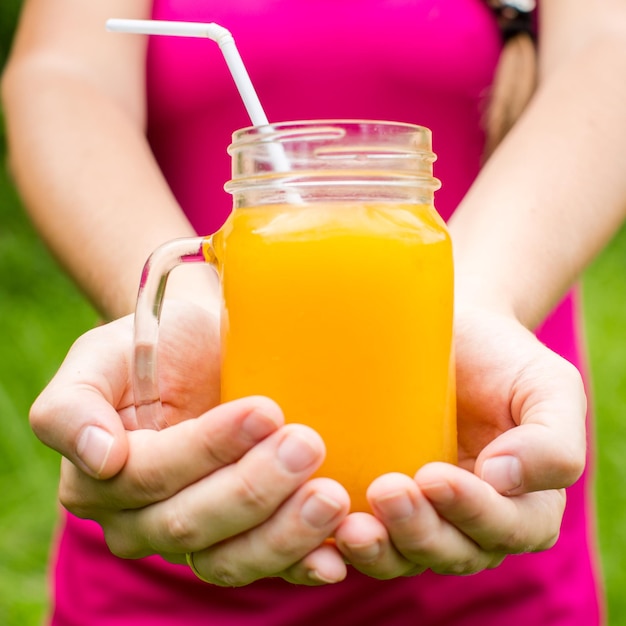 Mulher fitness segurando um copo de suco de laranja