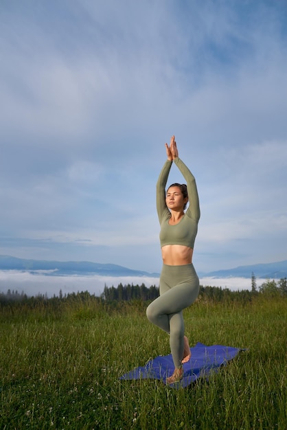 Foto grátis mulher fitness tendo prática de ioga ao ar livre