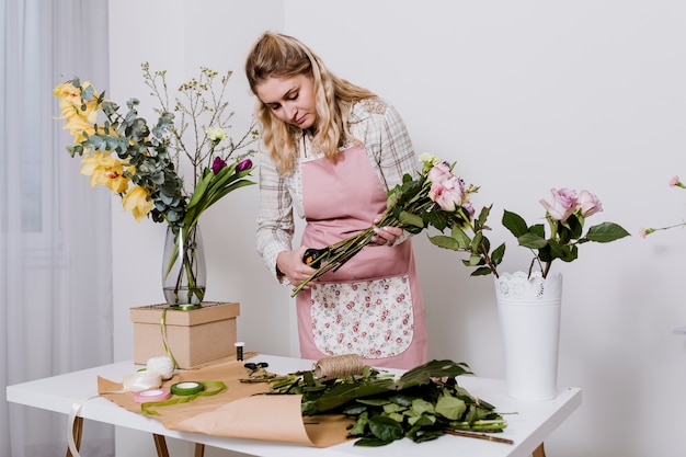 Mulher florista cortando flores antes do envoltório