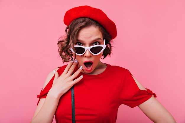 Mulher francesa encaracolada chocada olhando. senhora europeia emocional na boina isolada.