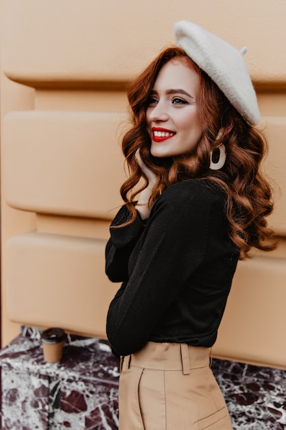 Mulher francesa inspirada com penteado longo, posando de boina elegante. retrato ao ar livre da despreocupada menina ruiva.