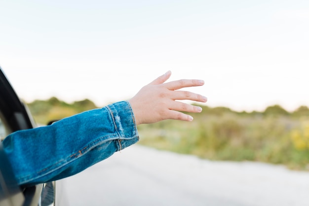 Foto grátis mulher furando ela tinha pela janela do carro