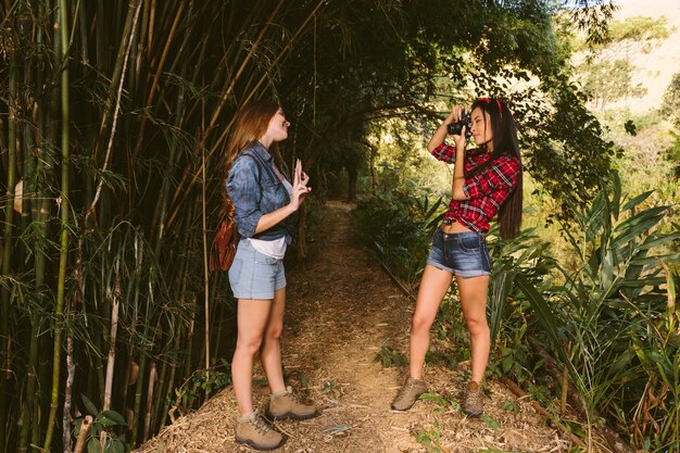 Mulher, gesticule, enquanto, dela, amigo, levando, fotografia, com, câmera