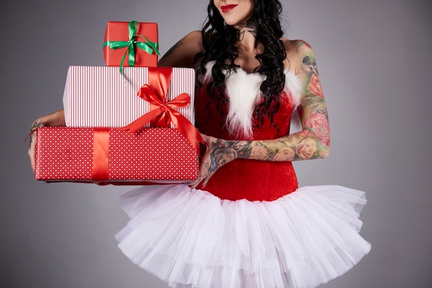 Foto grátis mulher glamorosa segurando uma pilha de presente de natal