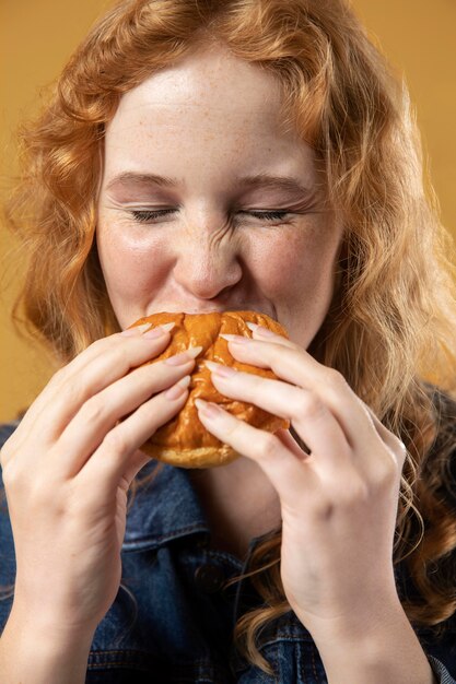 Mulher gostando de comer um hambúrguer