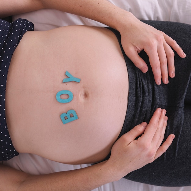 Foto grátis mulher grávida, com, menino, letras