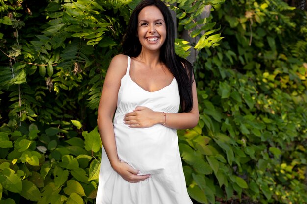 Mulher grávida com tiro médio segurando a barriga
