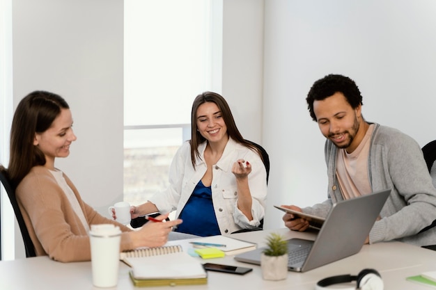 Mulher grávida conversando com seu colega de trabalho