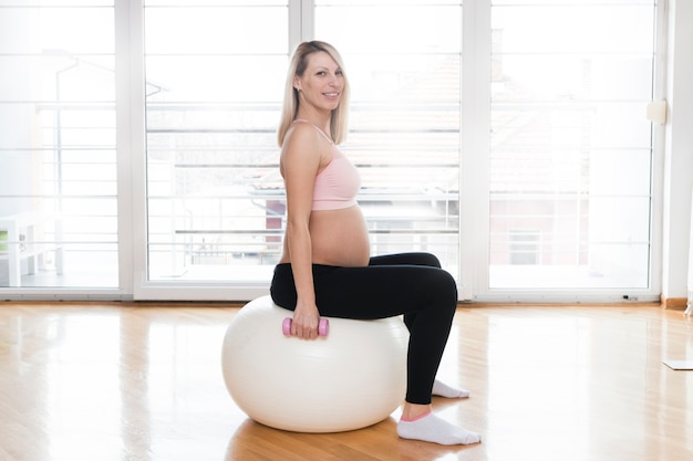 Mulher grávida na bola de ginástica