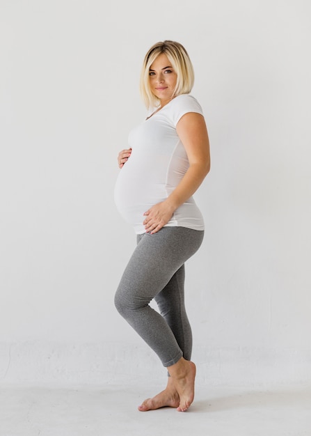 Mulher grávida posando enquanto olha para a câmera