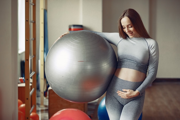 Foto grátis mulher gravida que treina em uma academia