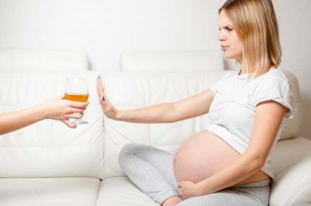 Mulher grávida se recusando a beber álcool