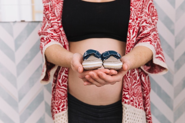 Foto grátis mulher grávida, segurando, sapatos bebê