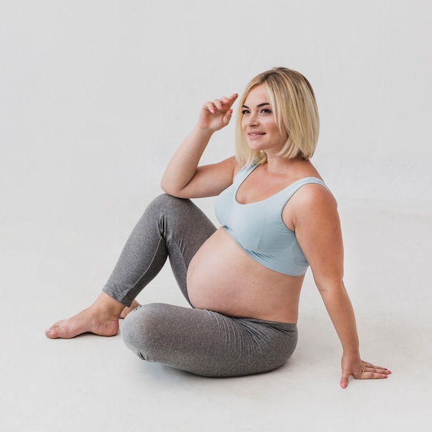 Mulher grávida sentada no chão