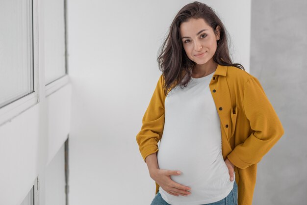 Mulher grávida sorridente com espaço de cópia