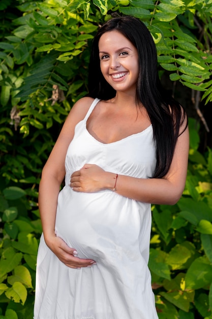 Mulher grávida sorridente de tiro médio posando